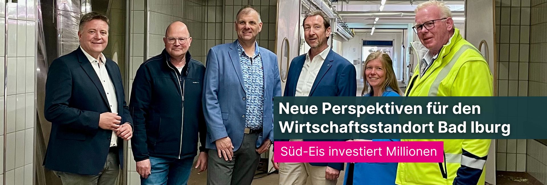 Besichtigung des zukünftigen Standorts der Süd-Eis GmbH & Co. KG im Gewerbegebiet Sentrup in Bad Iburg. Mehrere Personen stehen in den zukünftigen Produktionsräumen der ehemaligen Teutoburger Wurstfabrik. Im Bild eingeblendet: ‚Neue Perspektiven für den Wirtschaftsstandort Bad Iburg - Süd-Eis investiert Millionen‘.